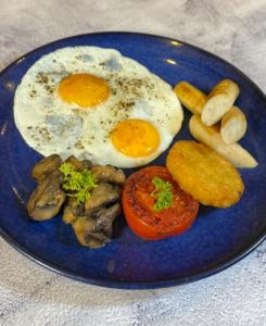 un plato azul de comida con huevos y setas en Parth Hotel, en Navi Mumbai