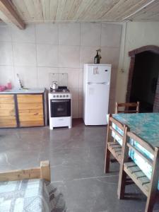 a kitchen with a white stove and a refrigerator at Macrigaluma Sol in Barra del Chuy