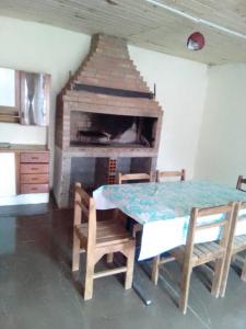 a dining room with a table and a fireplace at Macrigaluma Sol in Barra del Chuy