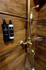 - un mur en bois avec deux bouteilles de savon et une douche dans l'établissement En Dimitsani, à Dimitsana