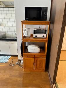 un microondas en un estante de una cocina en A201.KASUMI-an 花, en Shimo-tatsuda
