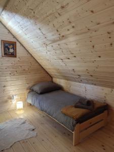 1 dormitorio con 1 cama en una cabaña de madera en Dzika Polana en Duszniki Zdrój