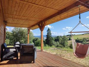 een veranda met een hangmat en stoelen erop bij Dzika Polana in Duszniki Zdrój