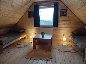 a room with two beds and a table in a attic at Dzika Polana in Duszniki Zdrój