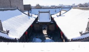 una vista aérea de los tejados nevados de los edificios en Pingyao Yide Hotel, en Pingyao