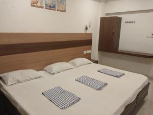 a bedroom with a bed with two towels on it at Hotel Alankar in Kanyakumari