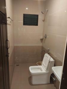uma casa de banho com um WC branco e um lavatório. em Hotel Alankar em Kanyakumari