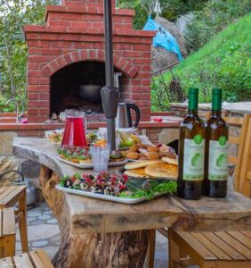 Shuakhevi的住宿－Guest House Okropilauri，一张桌子,上面放着两盘食物和瓶装葡萄酒