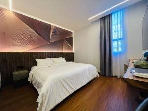 um quarto com uma cama branca e uma janela em Cyther Stay Hotel em Tawau