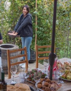 kobieta stojąca przed stołem z jedzeniem w obiekcie Guest House Okropilauri w mieście Shuakhevi