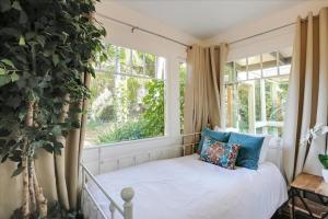 a bed in a room with a window at Hammonds Beach Haven in Santa Barbara