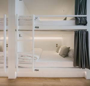 a room with two bunk beds with white walls at Matini Hostel grandstation in Bang Su