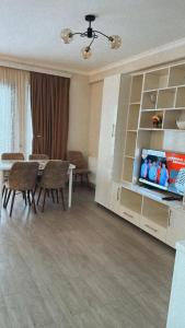 a living room with a dining table and a tv at Vitali Apartment in Borjomi