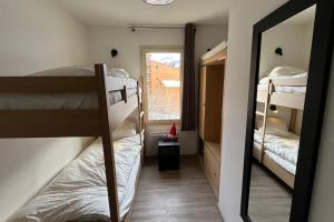 Pokój z 2 łóżkami piętrowymi i lustrem w obiekcie Refuge des Vues Alpines Isola 2000 w mieście Isola 2000