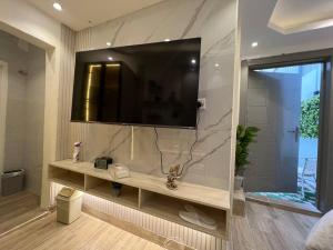 een badkamer met een wastafel en een televisie aan de muur bij Riyadh Single Studio in Riyad