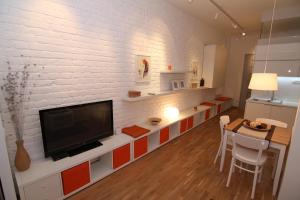 un salon avec une télévision sur un mur de briques blanches dans l'établissement Apartments Centro, à Belgrade