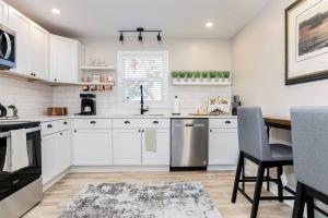a kitchen with white cabinets and a table and chairs at South Bend Serenity: Freshly Renovated 3BR 2mi ND in South Bend