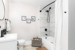a white bathroom with a shower and a toilet at South Bend Serenity: Freshly Renovated 3BR 2mi ND in South Bend