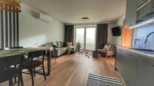 a kitchen and living room with a table and a couch at Gojka Apartamenty in Piekielnik