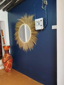 a mirror on a blue wall next to a vase at Seafarers Loft in Stone Town