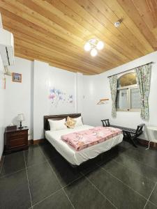 太麻里的住宿－金崙裕豐民宿，一间卧室设有一张床和木制天花板