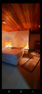 1 dormitorio con 1 cama y 2 luces en la pared en Apartamento Campos do Jordão en Campos do Jordão