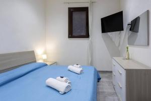 ein Schlafzimmer mit zwei Handtüchern auf einem blauen Bett in der Unterkunft Tampasio Apartment Trapani centro in Trapani