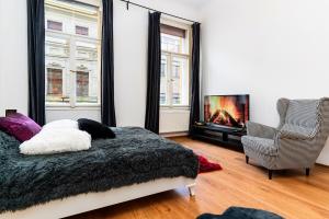 a bedroom with a bed and a fireplace and a chair at Black Gold Kingdom in Prague