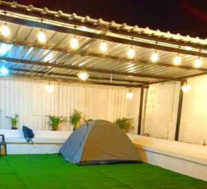 a tent sitting inside of a garage with lights at Raghav's guest house in Chikmagalūr