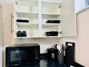 a kitchen with a microwave and a counter top at Town Centre Modern 1 Bed 1 Bath Apartment at Potter House by Lord Property in Aldershot