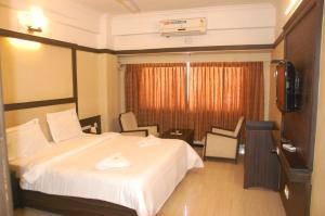 a hotel room with a bed and a television at Hotel Blue Star in Coimbatore