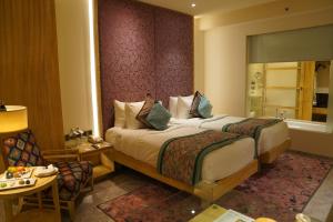 um quarto de hotel com uma cama e uma cadeira em Hotel Royal Orchid Jaipur, Tonk Road em Jaipur