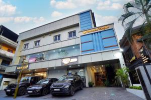 un edificio con tre auto parcheggiate di fronte di UNIVERSAL RESIDENCY a Perumpāvūr