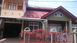 a house with a gate in front of it at KHAIRI HOMESTAY in Bukittinggi