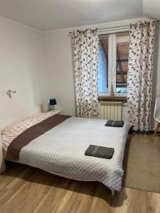 a bedroom with a bed and a window with curtains at Pokoje w miasteczku przy Puszczy Bialowieskiej in Hajnówka