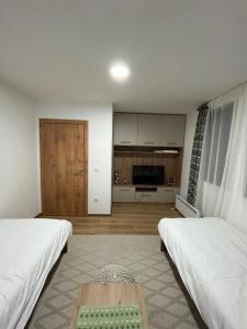 ein Zimmer mit zwei Betten und einem Tisch darin in der Unterkunft M Lux Kopaonik in Kopaonik