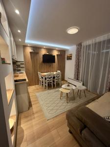 ein Wohnzimmer mit Couch und Tisch und eine Küche in der Unterkunft M Lux Kopaonik in Kopaonik