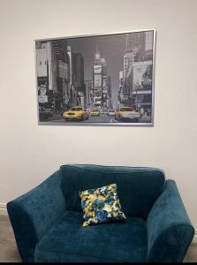 a blue couch in a room with a picture of a city at 4 Bedroom House, Central City Location in Newcastle upon Tyne