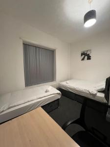 a room with two beds and a window at 4 Bedroom House, Central City Location in Newcastle upon Tyne