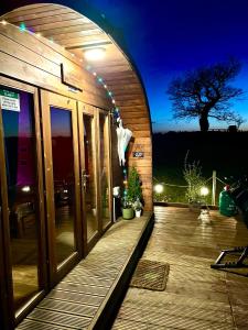 a building with a wooden deck at night at FINN VILLAGE – Loch Lomond Luxury Lodges with All Year-Round Hot Tubs and Gazebos in Glasgow