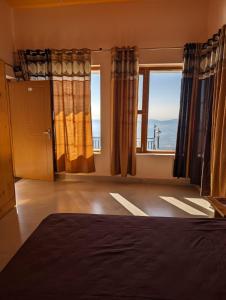 um quarto com uma cama e vista para o oceano em Kedara Stays em Mussoorie