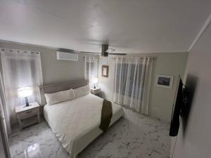 sypialnia z łóżkiem, dwoma stołami i dwoma lampami w obiekcie Queen's Landing Island Paradise w Christiansted