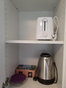 a tea kettle and a toaster sitting on a shelf at Studio 5min aéroport d'Orly 2 lits in Athis-Mons