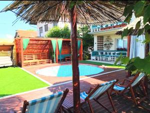 a house with a swimming pool with chairs and an umbrella at Villa Saturea in Boljevac