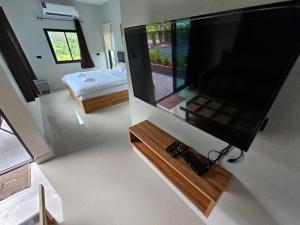 una grande TV a schermo piatto a parete in una camera di The Hill resort Thalang a Phuket