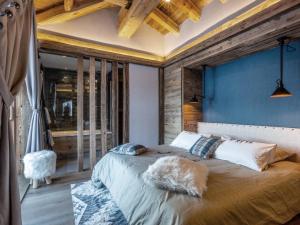 a bedroom with a large bed with a blue wall at Chalet Val-d'Isère, 8 pièces, 12 personnes - FR-1-694-3 in Val-d'Isère