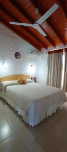 a bedroom with a large white bed with a ceiling at Apart hotel Residencial El Puma in Mina Clavero