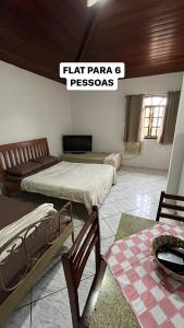 Habitación con 2 camas, mesa y sillas en Flat Búzios Temporada, en Búzios