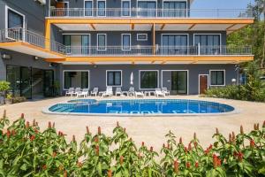 a house with a swimming pool in front of it at Sj House Hotel Aonang in Ban Khlong Haeng