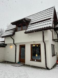 a house covered in snow with at Casa Matteo - Rustic & cosy getaway in Zărnești in Zărneşti